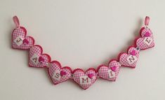 a pink and white heart shaped necklace with initials on it