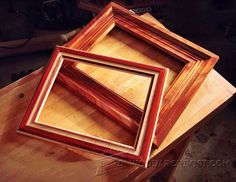 three frames sitting on top of a wooden table next to a pair of wrenches