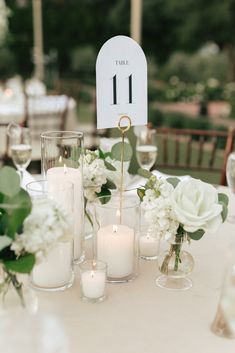 the table is set with candles, flowers and place cards for guests to sit at