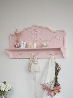 a pink shelf that has some flowers on it