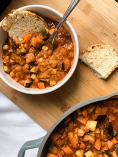 a bowl of stew next to a loaf of bread