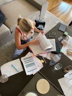 a woman sitting at a table with lots of papers