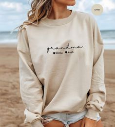 This custom Grandma Sweatshirt is the perfect gift for any proud grandmother! Personalize it with the names of her beloved grandkids to make it truly special. Whether she goes by Grammy, Mimi, Gigi, or Nana, this cozy sweater will warm her heart every time she wears it. Give her a meaningful present that celebrates her well-deserved promotion to Grandma, and make her smile every time she puts it on. Surprise her with this thoughtful and unique gift that she will cherish for years to come. PRODUC Grammy Sweatshirt, Nana Sweatshirt, Grandma Sweatshirt, Make Her Smile, Gift For Grandma, Cozy Sweater, Her Smile, Grandma Gifts, Cozy Sweaters