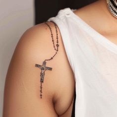 a woman with a cross tattoo on her shoulder