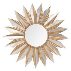 a gold and white sunburst mirror on a wall