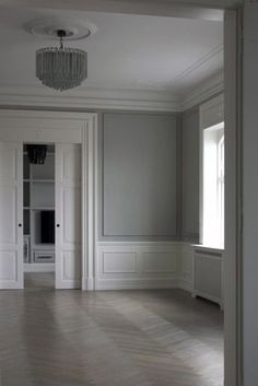 an empty room with white walls and wood floors