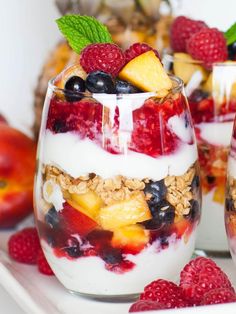 fruit and yogurt parfait in glasses with fresh berries on the side