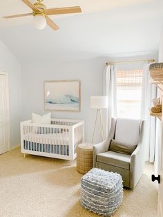 a baby's room with a crib, chair and ottoman