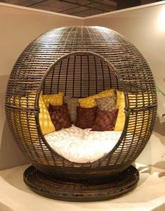 a wicker bed with pillows in the shape of a ball