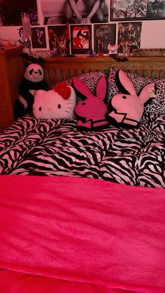 a bed with pink sheets and stuffed animals on top of it in front of pictures