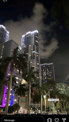 the city is lit up at night with palm trees