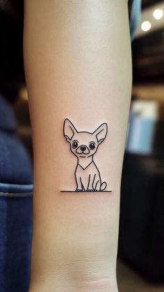 a small chihuahua tattoo on the right inner arm and leg, with an outline of a dog