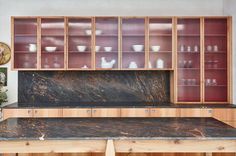 Neat row of fluted glass kitchen cabinets with their dark red interior softened and contents silhouetted by the glass. Wall Cabinet