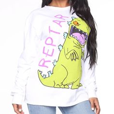 Fashion Nova Rawr Reptar Tee In White Size Small. Graphic Long Sleeved Tee With A Boyfriend Fit. 19” Underarm To Underarm, 30” Long From Neckline To Bottom At Center Of Back. All Measurements Are Approximate And Taken Laid Flat. Bundle With Other Items In My Closet And Save! Tote #3 Trendy Long Sleeve Cartoon Print Tops, Trendy Long Sleeve Tops With Cartoon Print, White Cartoon Print Tops For Spring, Spring White Cartoon Print Tops, Trendy White Cartoon Print Top, Trendy White Tops With Cartoon Print, Trendy White Top With Cartoon Print, Spring Funny Print Long Sleeve Tops, Stretch Crew Neck Top With Cartoon Print