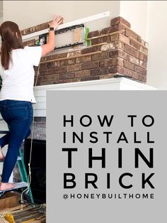 a woman in white shirt and blue jeans working on a brick wall with the words how to install thin brick