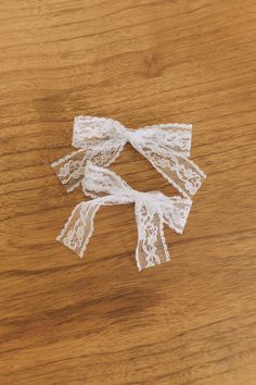 three pieces of white lace sitting on top of a wooden table