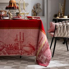 a dining room table covered in red and white linens with an ornate design on it