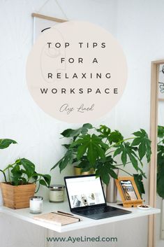 a laptop computer sitting on top of a white desk next to potted green plants