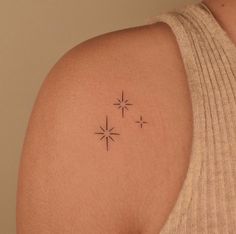 a woman's upper arm with three stars on the left side of her shoulder