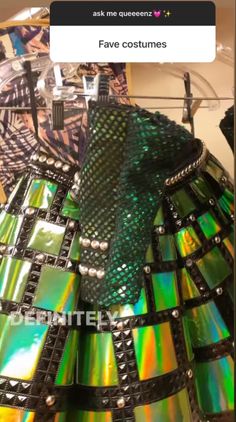 a green and black holographic dress on display in a store with the caption fake costumes