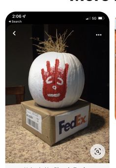 a fake handprinted pumpkin sitting on top of a box with the word fed ex painted on it