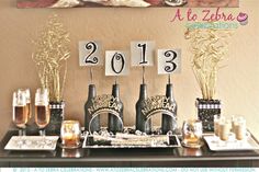 a table topped with wine bottles and glasses filled with champagne next to a sign that says 2013