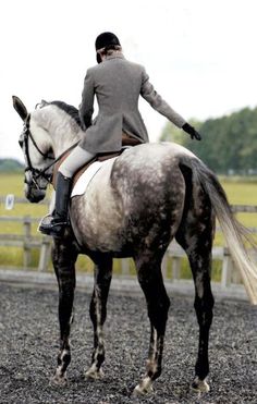 a woman riding on the back of a brown and white horse