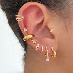 a woman with ear piercings and gold jewelry