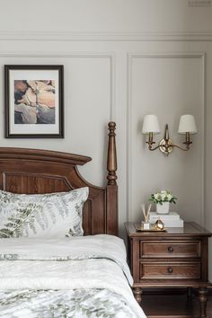 a bedroom with a bed, nightstand and two lamps