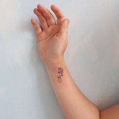 a woman's hand with a small rose tattoo on it