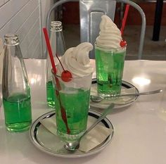 two glasses filled with green liquid and ice cream