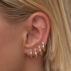 a close up of a person's ear with three different types of piercings