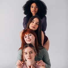 three women are posing for the camera with their arms around each other and one woman has her hands on her shoulders