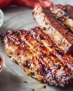 two pieces of meat sitting on top of a white plate next to ketchup