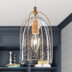 a light fixture hanging from a ceiling in a room with bookshelves and cabinets