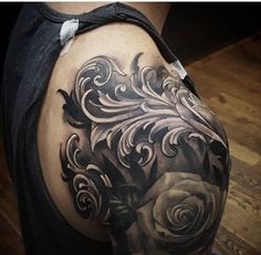 a black and white rose tattoo on the back of a woman's shoulder,