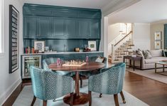 a dining room table with chairs around it and a chess board on the center piece