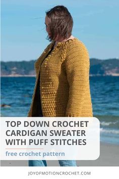 a woman standing on the beach wearing a yellow cardigan sweater with puff stitches and text overlay that reads top down crochet cardigan sweater with puff stitches