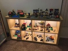 a display case filled with lots of legos on top of a carpeted floor