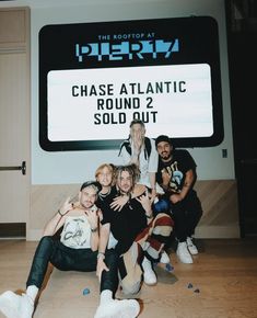 a group of people posing in front of a sign