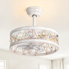 a white chandelier hanging from the ceiling in a room with windows and furniture