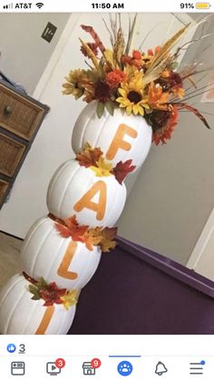 a tall white pumpkin decorated with fall leaves and the word fa is spelled on it