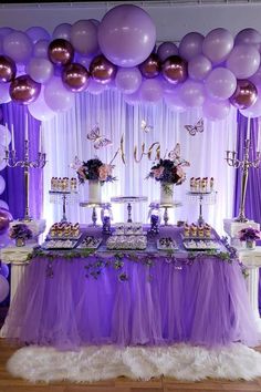 a purple and white dessert table with balloons