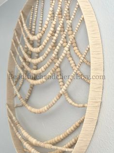 a circular wooden wall hanging with beads on it