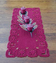 a crocheted placemat with two candles on it