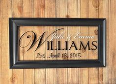 a wooden wall with a framed sign that says, duke and emma williams established on it