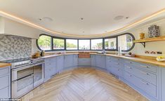 a large kitchen with wooden floors and blue cabinetry is pictured in this image from the inside