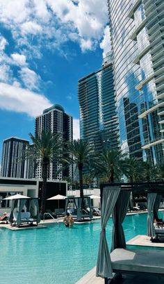 an outdoor swimming pool surrounded by tall buildings