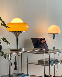 a table with two lamps on it and a laptop computer sitting on top of it