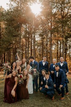 a group of people standing next to each other in front of trees